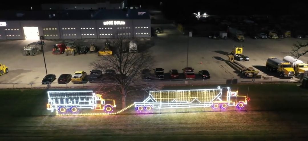 A large holiday light display of a truck connecting with another truck.