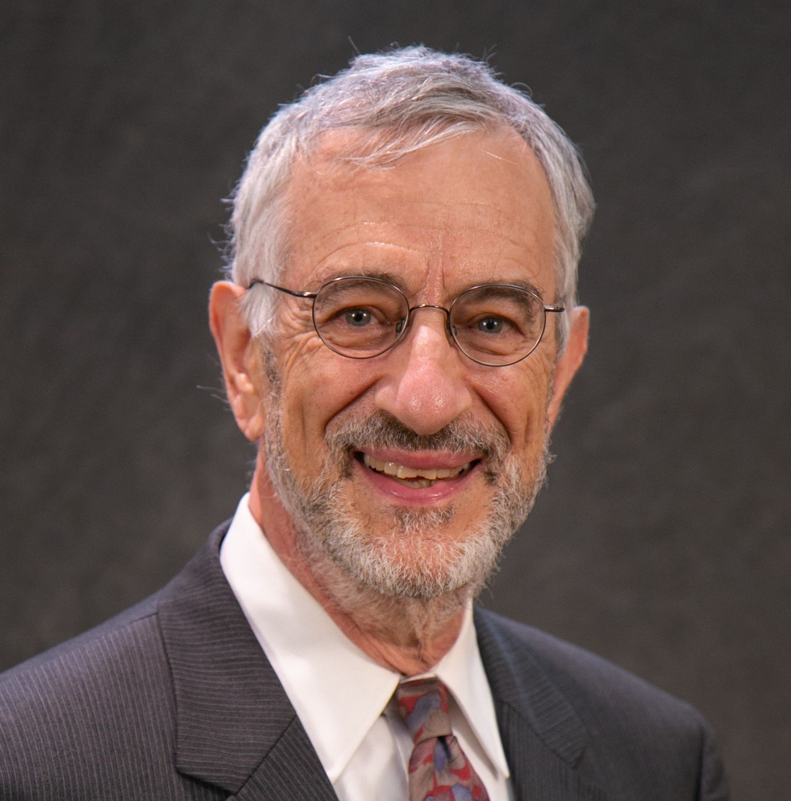 Headshot of a man with silver hair.